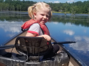 Goodale State Park Canoe Trail witha smiling child on the front of a canoe looking back into the camera