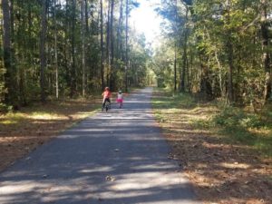 A little boy and a little girl riding bikes on paved trail at Sweet Gum Trail